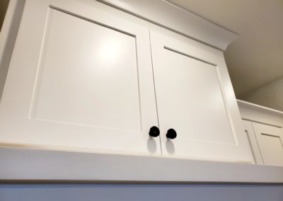 Flat Black T-Bar Knob Up Close White Cabinet