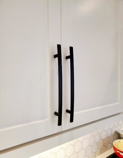 Flat Black Subtle Arch Handles on White Shaker Kitchen Cabinet Close Up