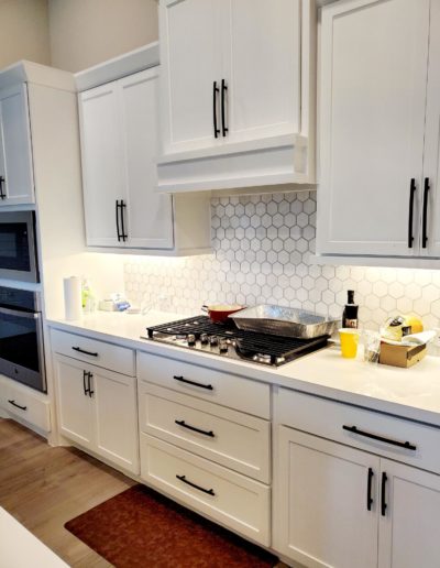 Flat Black Subtle Arch Handles on White Shaker Upper Kitchen Cabinets